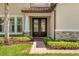 Inviting entryway featuring a brick walkway, double doors with glass inserts, and manicured landscaping at 163 Rosa Bella Vw, Debary, FL 32713