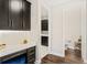 Hallway with built-in desk, dark cabinetry, and views into the powder room at 163 Rosa Bella Vw, Debary, FL 32713