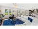 Bright living room with white couches, blue rug, and multiple doors to the backyard at 163 Rosa Bella Vw, Debary, FL 32713