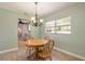 Bright dining area features tile floors, a wooden table with seating for four, and an elegant chandelier at 1650 Jacobs Rd, South Daytona, FL 32119