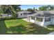 Expansive backyard with healthy grass, a cozy patio, and an enclosed sunroom at 1715 Queen Palm Dr, Edgewater, FL 32132