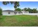 Spacious backyard featuring a well-maintained lawn and a pristine white privacy fence at 1715 Queen Palm Dr, Edgewater, FL 32132