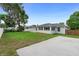 Green backyard with patio and partial view of house and sun room at 1715 Queen Palm Dr, Edgewater, FL 32132