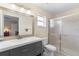 Well-lit bathroom with gray vanity, large mirror, and glass-enclosed shower at 1715 Queen Palm Dr, Edgewater, FL 32132