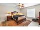 Cozy bedroom featuring a dark wood bed frame, area rug, and natural light from the window at 1715 Queen Palm Dr, Edgewater, FL 32132