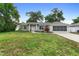 Charming single-story home features a well-maintained lawn and a screened garage at 1715 Queen Palm Dr, Edgewater, FL 32132