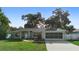Well-kept single-story home with green lawn, charming walkway, and a screened garage at 1715 Queen Palm Dr, Edgewater, FL 32132