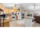 Spacious kitchen with white appliances, wood cabinets, central island, and overhead ceiling fans at 1715 Queen Palm Dr, Edgewater, FL 32132