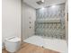Beautiful bathroom features a frameless shower with leaf-patterned tile, modern fixtures, and a sleek toilet at 1841 Spruce Creek Blvd, Port Orange, FL 32128