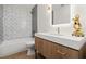 Modern bathroom with stylish vanity, unique tiles, modern fixtures, and a shower-tub combination at 1841 Spruce Creek Blvd, Port Orange, FL 32128