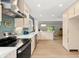 Open kitchen featuring modern appliances, stylish countertops, pendant lighting, and hardwood floors at 1841 Spruce Creek Blvd, Port Orange, FL 32128