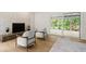 Bright living room with hardwood floors, fireplace, modern chairs, and sliding glass doors to the patio at 1841 Spruce Creek Blvd, Port Orange, FL 32128