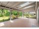 Bright sunroom featuring skylights and brick flooring with views of the landscaped backyard at 1841 Spruce Creek Blvd, Port Orange, FL 32128