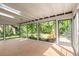 Bright sunroom featuring skylights and brick flooring with views of the landscaped backyard at 1841 Spruce Creek Blvd, Port Orange, FL 32128