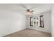 Bedroom features neutral carpet, ceiling fan, and window, providing a comfortable living space at 1930 Harston Trl, The Villages, FL 32162