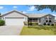 Charming single-story home with a well-manicured lawn and a two-car garage at 1930 Harston Trl, The Villages, FL 32162
