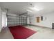 Spacious two-car garage featuring a large garage door, ample storage, and a red carpet at 1930 Harston Trl, The Villages, FL 32162