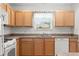 Well-lit kitchen featuring stainless steel appliances, wood cabinets, and light countertops at 1930 Harston Trl, The Villages, FL 32162