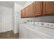 Functional laundry area equipped with washer, dryer, and cabinets for organized convenience at 1930 Harston Trl, The Villages, FL 32162