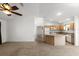 Spacious living room and kitchen features neutral paint, carpet, ceiling fan, and lots of natural light at 1930 Harston Trl, The Villages, FL 32162