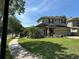 Charming two-story home featuring a well-manicured lawn, beautiful landscaping, and long driveway at 201 Asterbrooke Dr, Deland, FL 32724