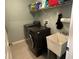 Convenient laundry room features a washer and dryer, utility sink, and storage shelves for supplies at 201 Asterbrooke Dr, Deland, FL 32724