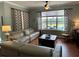 Bright living room featuring hardwood floors, a large window overlooking the pool area, and comfortable seating at 201 Asterbrooke Dr, Deland, FL 32724