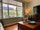 View of a cozy living room with hardwood floors, large window and a view of a private pool outside at 201 Asterbrooke Dr, Deland, FL 32724