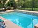 Sparkling pool with waterfall feature and ample patio seating area, perfect for outdoor entertaining at 201 Asterbrooke Dr, Deland, FL 32724