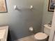 Cozy powder room includes a granite vanity top, toilet, and decorative artwork on the walls at 201 Asterbrooke Dr, Deland, FL 32724