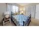 Bedroom with a blue patterned comforter on a black iron bed frame, side tables, and a closet at 2101 N Atlantic Ave # 10, Daytona Beach, FL 32118