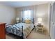 Bedroom with a blue patterned comforter on a black iron bed frame, neutral walls, and bright natural light at 2101 N Atlantic Ave # 10, Daytona Beach, FL 32118