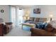 Relaxing living room with a comfortable sofa, armchair, and sliding glass doors leading to a balcony at 2101 N Atlantic Ave # 10, Daytona Beach, FL 32118
