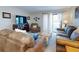 Comfortable living room featuring plush sofas, a wooden coffee table, and sliding glass doors at 2101 N Atlantic Ave # 10, Daytona Beach, FL 32118