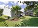 Well-maintained backyard featuring a covered patio, lush green grass, and shrubbery at 220 Asterbrooke Dr, Deland, FL 32724