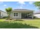 The backyard has a covered patio with a dining set and a lush green lawn at 220 Asterbrooke Dr, Deland, FL 32724
