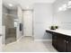 Bright bathroom with glass-enclosed shower, dark wood cabinets, and neutral tile at 220 Asterbrooke Dr, Deland, FL 32724