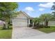 Beautifully landscaped single-Gathering home featuring a brick driveway and attached two-car garage at 220 Asterbrooke Dr, Deland, FL 32724