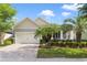 Charming single-story home with a well-manicured lawn and tropical landscaping including beautiful palm trees at 220 Asterbrooke Dr, Deland, FL 32724
