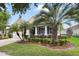 Inviting home featuring a lush, green lawn with decorative palm trees and a covered front porch at 220 Asterbrooke Dr, Deland, FL 32724