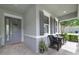 Welcoming front porch with gray door, matching shutters, and cozy seating area at 220 Asterbrooke Dr, Deland, FL 32724