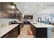 A modern kitchen featuring an island with a sink, stainless appliances and dark cabinetry at 220 Asterbrooke Dr, Deland, FL 32724