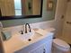 Bathroom featuring a white vanity, commode and a tiled walk-in shower at 2204 Poinsettia Dr, Deland, FL 32724