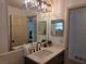 Bathroom features a modern sink, unique light fixture, and double mirror setup at 2204 Poinsettia Dr, Deland, FL 32724