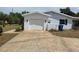 Home with driveway leading to the garage, featuring a well-maintained exterior and landscaping at 2204 Poinsettia Dr, Deland, FL 32724