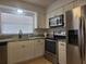 Bright kitchen featuring stainless steel appliances, white cabinets and granite countertops at 2204 Poinsettia Dr, Deland, FL 32724
