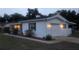 Well-maintained home exterior features a garage, manicured landscaping, and a freshly painted exterior at dusk at 2204 Poinsettia Dr, Deland, FL 32724