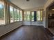 Inviting sunroom featuring wood-look floors, abundant windows, and backyard access at 2204 Poinsettia Dr, Deland, FL 32724