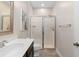 Neutral-toned bathroom showcasing a glass-enclosed shower and a single sink vanity at 2406 Kennington Cv, Deland, FL 32724