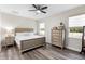 This bedroom features a queen bed, two windows, and a gray dresser at 2406 Kennington Cv, Deland, FL 32724